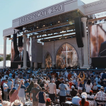 2026-rededication - California Family Council Outdoor concert or ceremony with a large stage and screens; a man speaks at a podium while a crowd listens, banner reads REDEDICATE 250, patriotic badge at left corner.