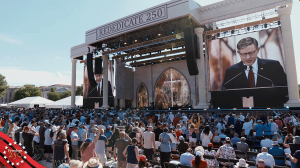 2026-rededication - California Family Council Outdoor concert or ceremony with a large stage and screens; a man speaks at a podium while a crowd listens, banner reads REDEDICATE 250, patriotic badge at left corner.
