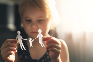 Image 7-2-26 at 434 PM - California Family Council Young girl holding a paper cutout of a family connected by hands, symbolizing family unity.